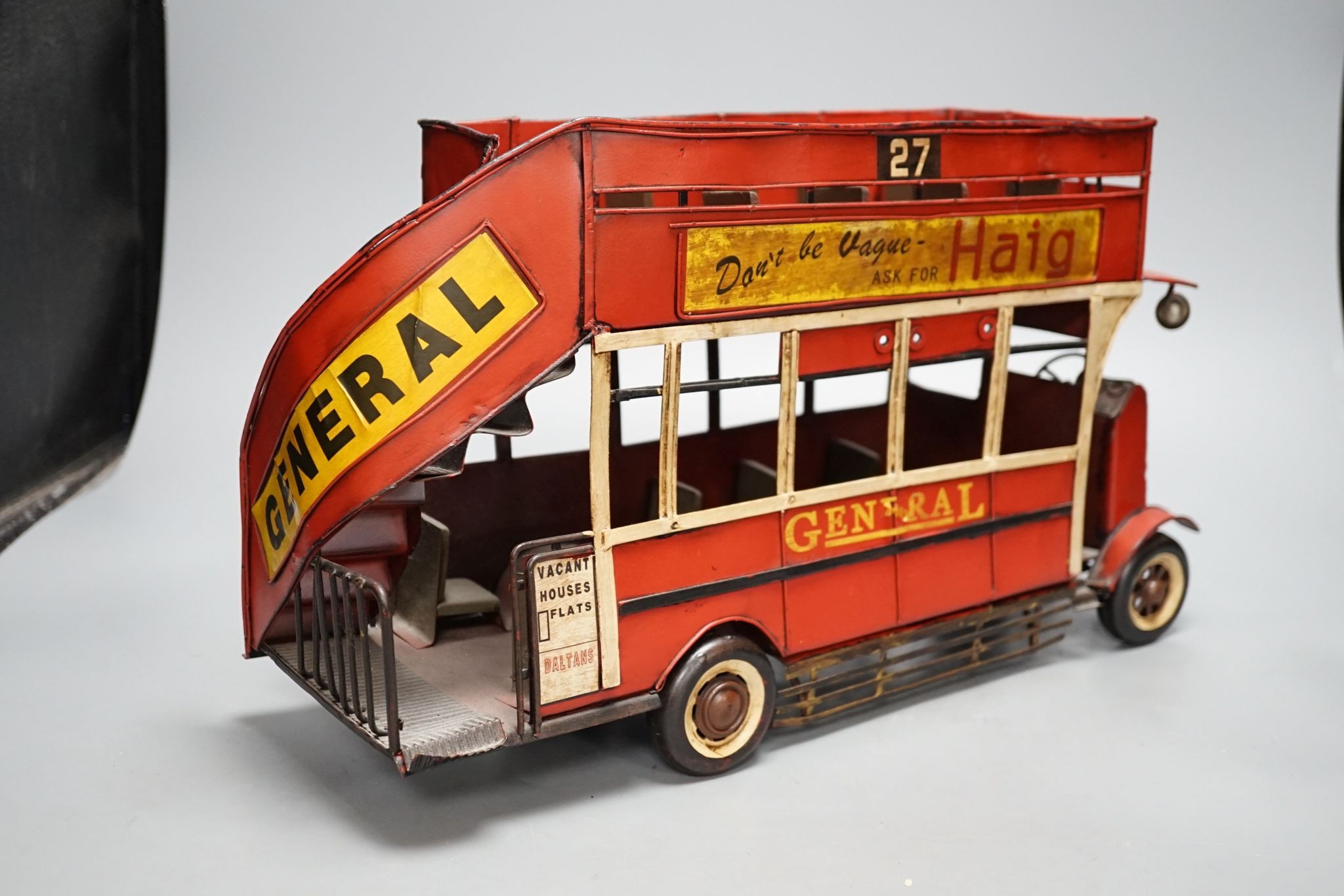 A reproduction tinplate double decker topless bus, the side reading ‘Don’t be vague - ask for Haig’, 42cm long